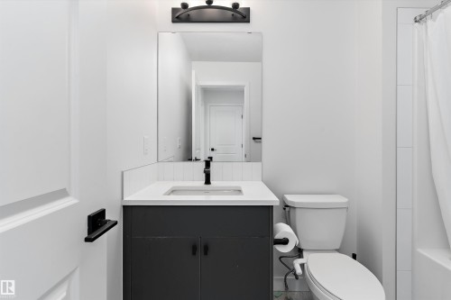 Contemporary bathroom vanity featuring a rectangular undermount sink, a light-toned countertop, and a dark base cabinet - 1439 Goodspeed Lane Nw, Edmonton, AB - Indoor Photo Showing Bathroom