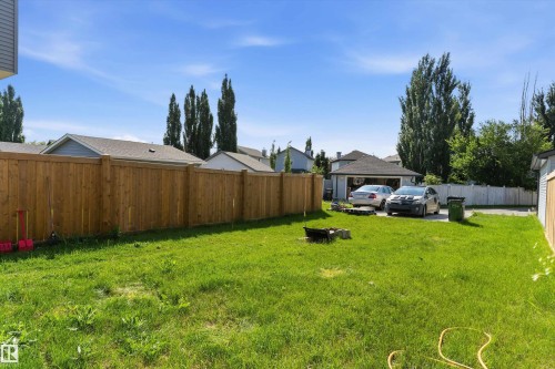Expansive green lawn with a wood plank fence - 1439 Goodspeed Lane Nw, Edmonton, AB - Outdoor With Backyard
