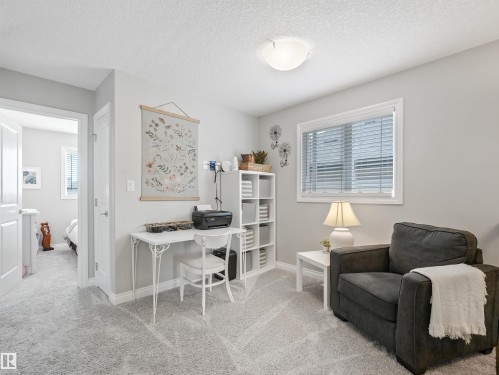 Carpeted room with a window featuring horizontal blinds, a white ceiling light fixture, and a built-in shelving unit - 283 Ameena Drive, Leduc, AB - Indoor