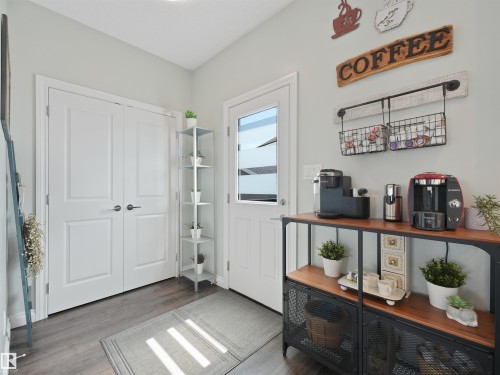 Entryway featuring light gray walls, dark wood-finish flooring, and white double doors - 283 Ameena Drive, Leduc, AB - Indoor Photo Showing Other Room