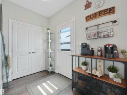 Entryway featuring light gray walls, dark wood-finish flooring, and white double doors - 