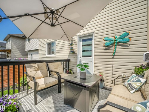 Spacious elevated deck featuring a privacy railing, neutral siding, and a white exterior door - 283 Ameena Drive, Leduc, AB - Outdoor With Exterior