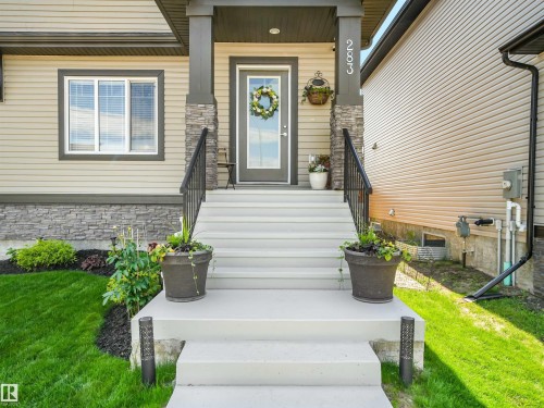 Inviting front entrance with concrete steps and black metal railings - 283 Ameena Drive, Leduc, AB - Outdoor With Exterior