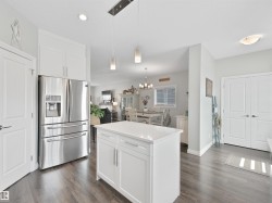 Kitchen featuring a central island with white cabinetry and a solid surface countertop - 