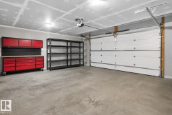 Spacious garage with a sectional overhead door, automatic opener, and a durable concrete floor - 