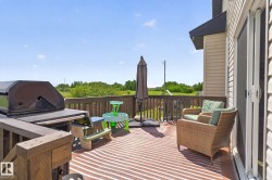 Spacious outdoor deck featuring wooden railing, a sliding patio door, and vinyl siding on the exterior - 