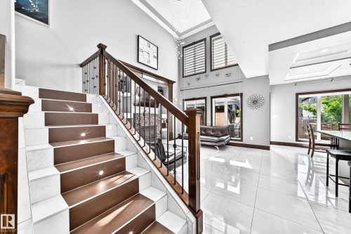 Grand entryway featuring a staircase with wood-finish treads and white risers, illuminated by embedded step lights - 16244 138 Street Nw, Edmonton, AB - Indoor Photo Showing Other Room