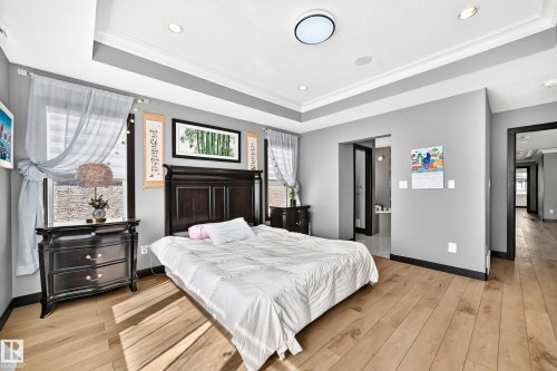 Bedroom featuring wood-finish flooring and a tray ceiling with recessed lighting - 16244 138 Street Nw, Edmonton, AB - Indoor Photo Showing Bedroom