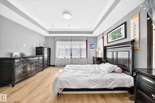 Room featuring light wood-finish flooring and tray ceiling with recessed lighting - 16244 138 Street Nw, Edmonton, AB - Indoor Photo Showing Bedroom