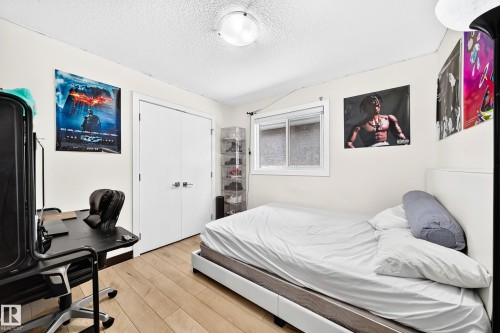 Room featuring wood-finish flooring, a window with white trim, and a ceiling-mounted light fixture - 16244 138 Street Nw, Edmonton, AB - Indoor Photo Showing Bedroom