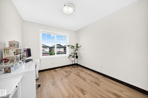 Room featuring wood-finish flooring, light-toned walls, and a white ceiling with a flush-mount light fixture - 16244 138 Street Nw, Edmonton, AB - Indoor Photo Showing Other Room