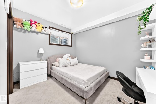 Carpeted bedroom featuring a single window with blinds, white floating shelves, and a built-in wall shelf - 16244 138 Street Nw, Edmonton, AB - Indoor Photo Showing Bedroom