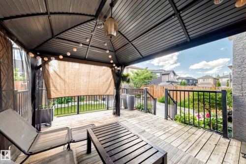 Expansive wooden deck featuring a built-in gazebo with a solid roof, black metal railing, and privacy screening - 16244 138 Street Nw, Edmonton, AB - Outdoor With Deck Patio Veranda With Exterior