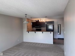 Open-concept living area featuring a breakfast bar with dark wood-finish countertops and dark cabinetry - 