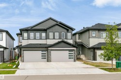 Modern two-story residence featuring a dark gray and light gray siding exterior - 