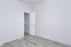 Light gray wood-finish flooring complements crisp white walls - 