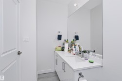 Modern bathroom vanity featuring a light-colored countertop with an integrated sink and sleek cabinet hardware - 