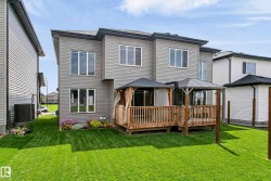Rear exterior featuring grey horizontal siding and multiple large windows - 