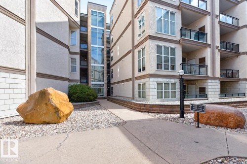 Multi-story residential building with stucco and stone facade - #100 4835 104A St Nw, Edmonton, AB 