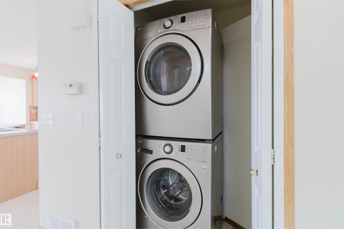 Stackable laundry appliances within a dedicated closet - 1686 Tompkins Wynd Nw, Edmonton, AB - Indoor Photo Showing Laundry Room