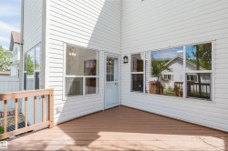 Spacious outdoor deck with wood-finish flooring and light wood railing - 