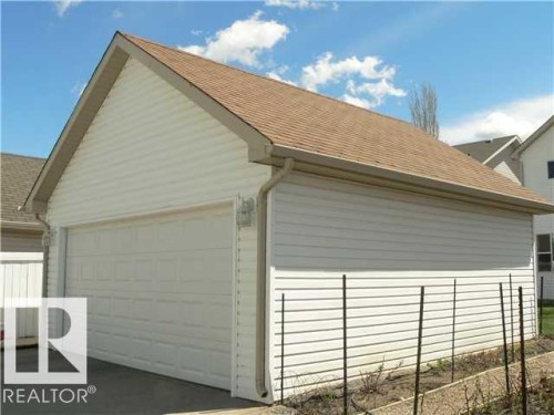 Detached garage featuring white horizontal siding and a brown shingled roof - 1686 Tompkins Wynd Nw, Edmonton, AB - Outdoor With Exterior