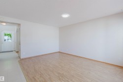 Open-concept living space featuring wood-finish flooring and a recessed ceiling light - 