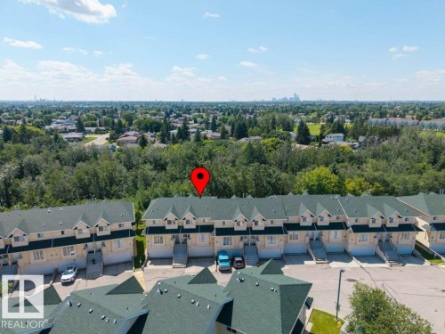 Townhome row featuring light-toned siding and dark green gabled roofs - #39 2419 133 Av Nw, Edmonton, AB - Outdoor With View