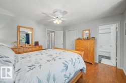 Bedroom featuring hardwood-finish flooring, light grey wall paint, and a ceiling fan with integrated lighting - 