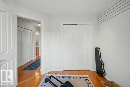 Hardwood flooring extending throughout, complemented by white walls and trim - #39 2419 133 Av Nw, Edmonton, AB - Indoor