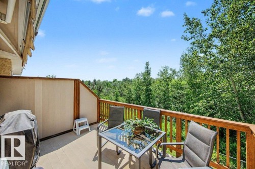 Upper-level deck featuring composite decking, wood railing, and privacy paneling, overlooking a treed landscape - #39 2419 133 Av Nw, Edmonton, AB - Outdoor With Deck Patio Veranda With Exterior