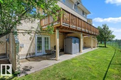 Lower-level patio with double French doors and an overhead wooden deck - 