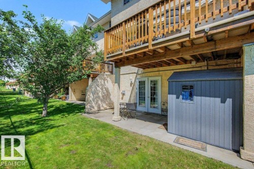 Expansive backyard featuring a manicured lawn, established tree, and concrete patio - #39 2419 133 Av Nw, Edmonton, AB - Outdoor
