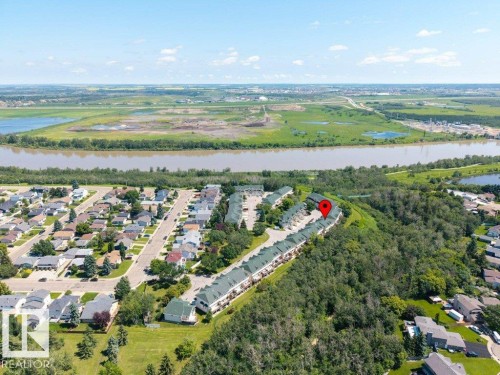Aerial perspective showcasing a residential area bordered by a river and green spaces - #39 2419 133 Av Nw, Edmonton, AB - Outdoor With View