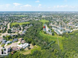 Residential neighborhood featuring mature trees, green spaces, and a winding path - 