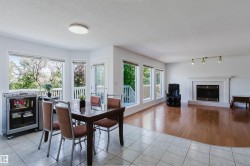 Open-concept living area featuring a fireplace with a mantel, multiple large windows, and a glass-paneled door - 