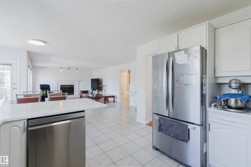 Kitchen featuring white cabinetry, stainless steel appliances, and a light-toned countertop - 15 Cormack Crescent Nw, Edmonton, AB - Indoor Photo Showing Kitchen