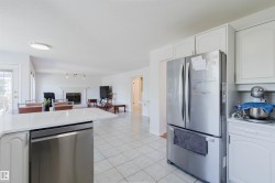 Kitchen featuring white cabinetry, stainless steel appliances, and a light-toned countertop - 