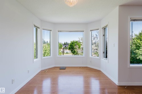 Bay window with multiple large glass panels, wood-finish flooring, white walls, and a ceiling-mounted light fixture - 15 Cormack Crescent Nw, Edmonton, AB - Indoor Photo Showing Other Room