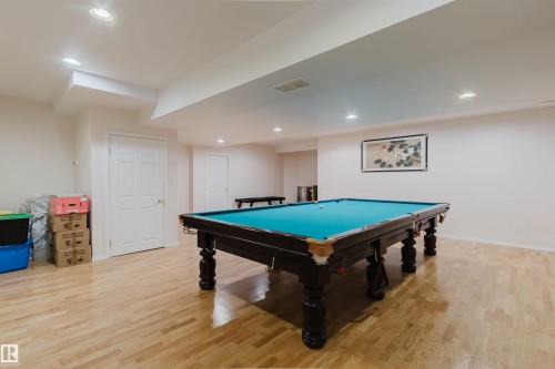 Spacious recreation area featuring light wood-finish flooring, recessed lighting, and white paneled doors - 15 Cormack Crescent Nw, Edmonton, AB - Indoor Photo Showing Other Room