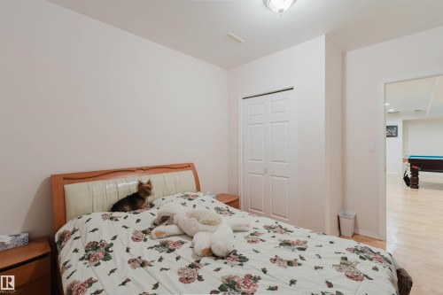 Bedroom with light wood-finish flooring, white walls, and a ceiling-mounted light fixture - 15 Cormack Crescent Nw, Edmonton, AB - Indoor Photo Showing Bedroom