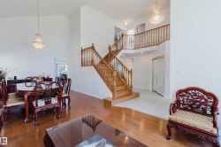 Grand two-story foyer with a natural wood staircase and balustrade - 