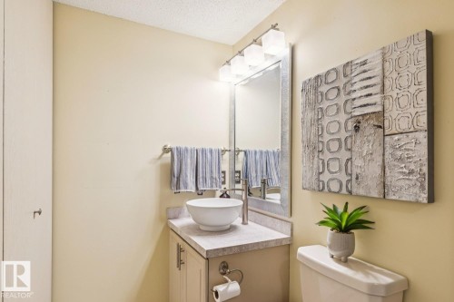 Bathroom featuring a vessel sink with a brushed nickel faucet, a vanity with cabinet storage, and a framed mirror - 15804 80 Street Nw, Edmonton, AB - Indoor Photo Showing Bathroom