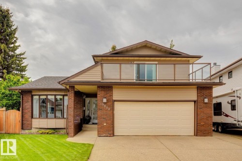 Exterior featuring brick and siding finishes, an attached garage, a covered front entry, a second-story balcony with glass railing, and a bay window - 15804 80 Street Nw, Edmonton, AB - Outdoor