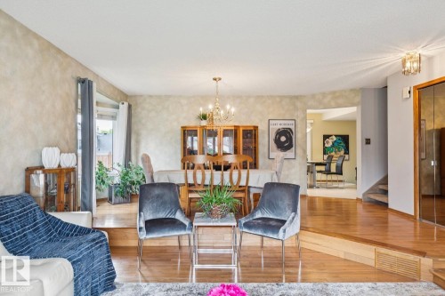 Multi-level interior featuring wood-finish flooring, a dining area with a chandelier, and a recessed entryway - 15804 80 Street Nw, Edmonton, AB - Indoor Photo Showing Living Room