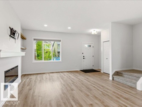 Open-concept living area with wood-finish flooring, recessed lighting, and an electric fireplace - 17487 77 Street, Edmonton, AB - Indoor With Fireplace