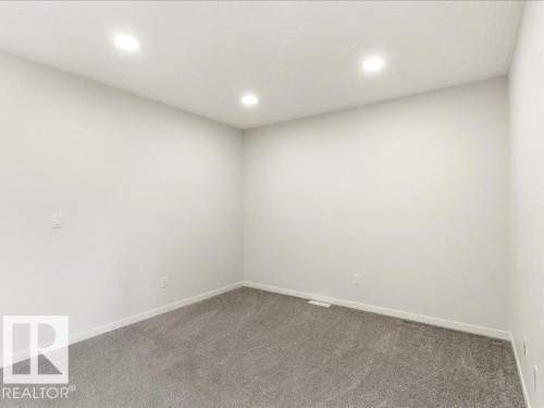 Neutral-toned room featuring recessed ceiling lighting, light gray wall paint, and gray carpeting - 17487 77 Street, Edmonton, AB - Indoor Photo Showing Other Room