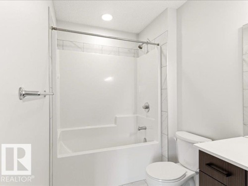 Modern bathroom featuring a white bathtub and shower combination with a tiled surround - 17487 77 Street, Edmonton, AB - Indoor Photo Showing Bathroom