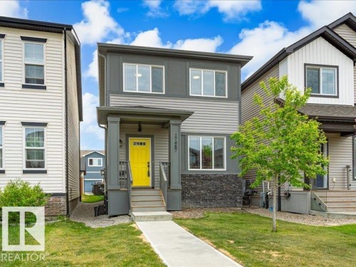 Modern two-story residence with a vibrant yellow front door and covered entry porch - 17487 77 Street, Edmonton, AB - Outdoor With Facade