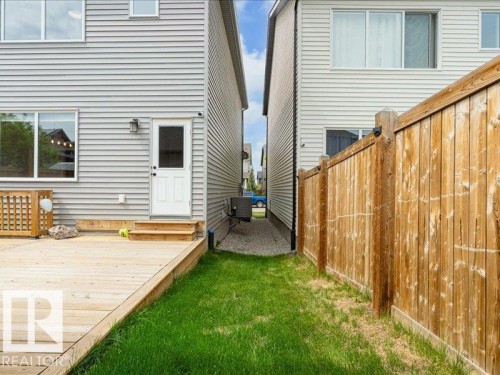 Rear exterior featuring light grey siding, a white door, and multiple windows - 17487 77 Street, Edmonton, AB - Outdoor With Exterior